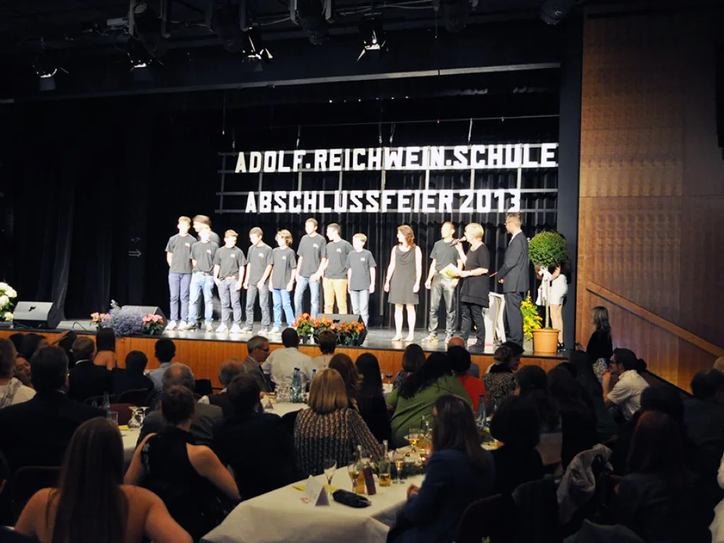 Gruppe steht bei der Übergabe auf der Bühne.